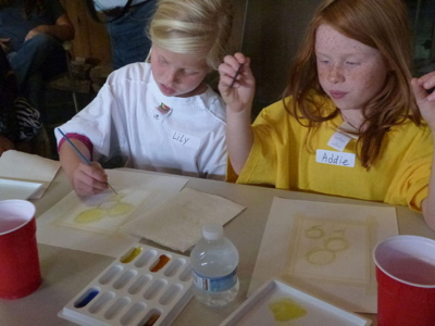 The girls work diligently. The sunflower petals, like rays of the sun, are painted in yellow